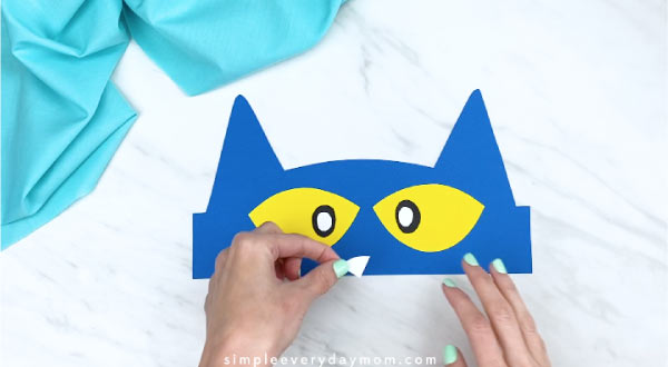 hands gluing on white nose onto Pete the Cat headband 