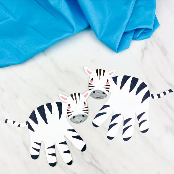 two handprint zebra crafts with blue fabric 