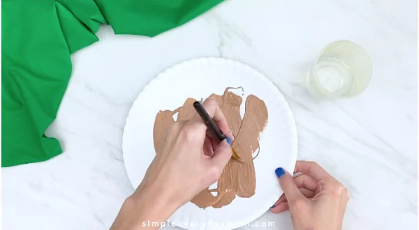 hands painting paper plate brown 