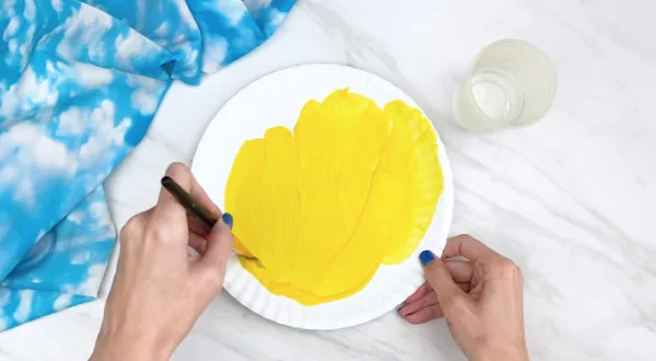 painting the bee's face with acrylic yellow paint