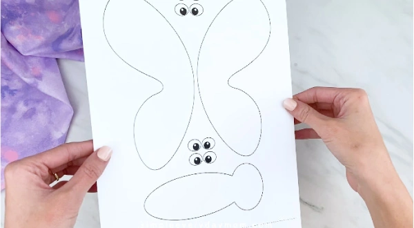 Hands holding butterfly craft template 