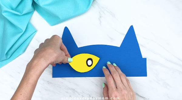 hands gluing completed eye to Pete the Cat headband 