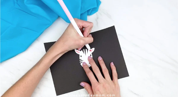 hand coloring in zebra ears with pink marker 