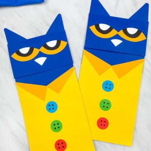 Two completed Pete the Cat paper crafts displayed side by side, featuring blue faces, yellow shirts, and blue, green, and red buttons.
