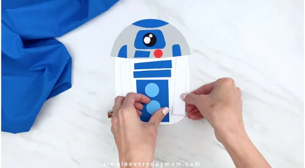 hands placing decorations on paper r2d2 craft
