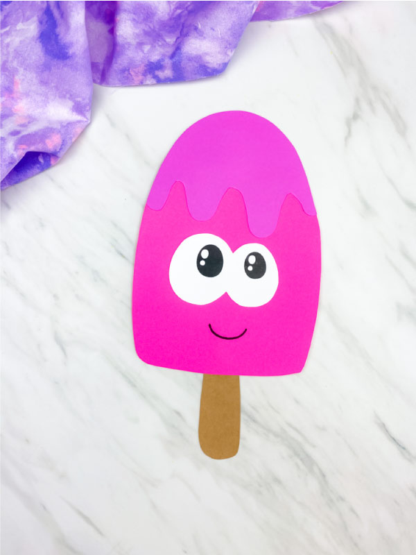 pink paper popsicle craft on marble background 
