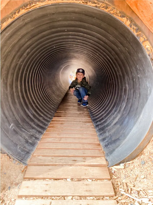 child in metal tube tunnel 
