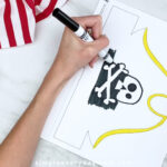 hands using markers to color in pirate hat