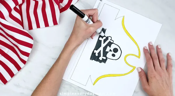hands using markers to color in pirate hat