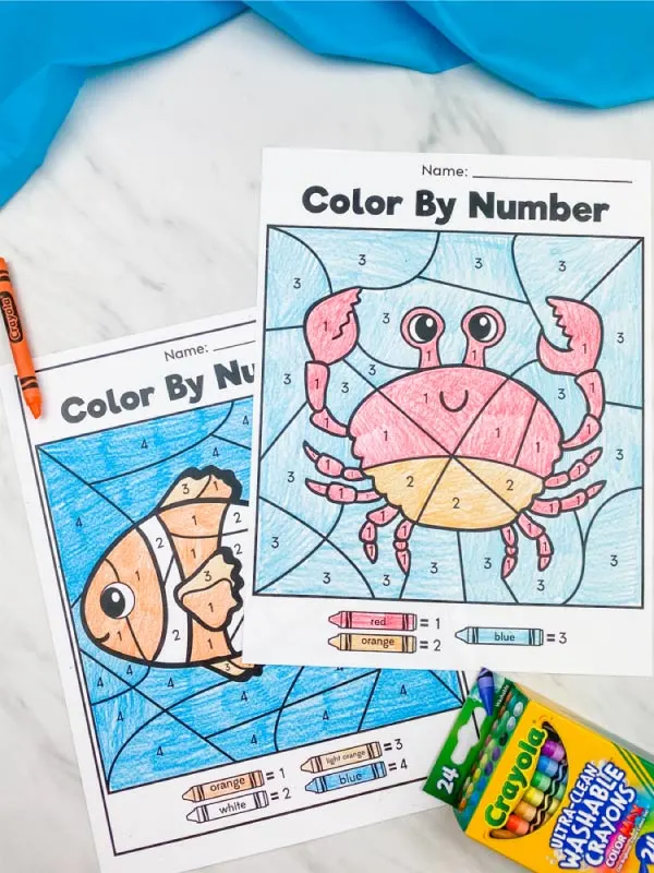 crab and clownfish color by number with orange crayon and box of crayons