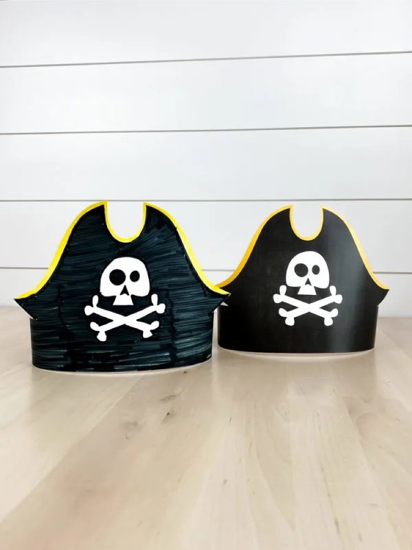two paper pirate headbands on wood table 