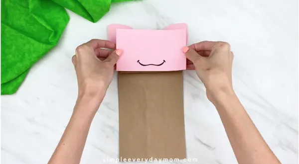 hand gluing on paper bag pig face 