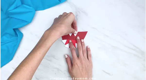 hands gluing on teeth to shark mouth 