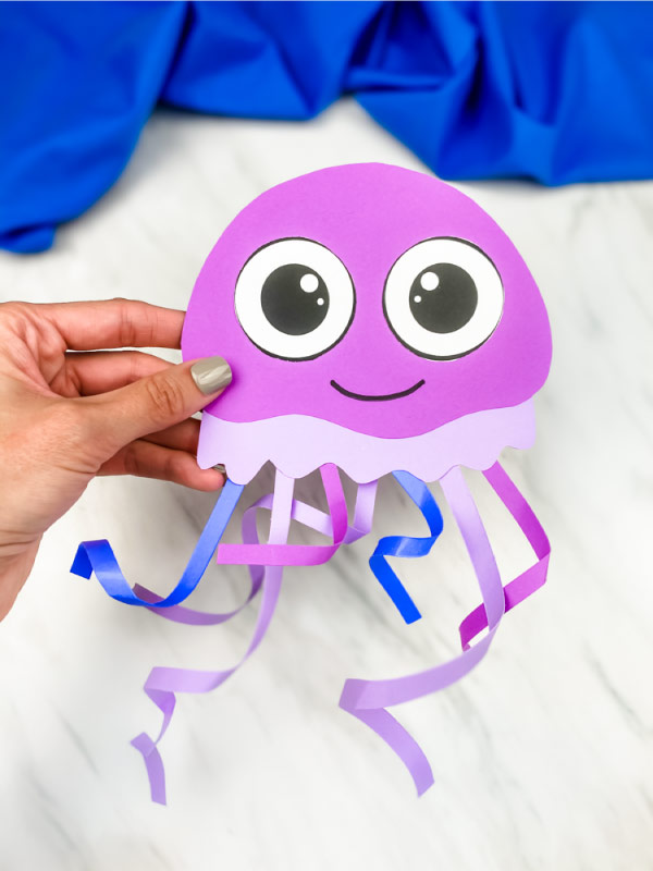 hand holding purple paper jellyfish craft