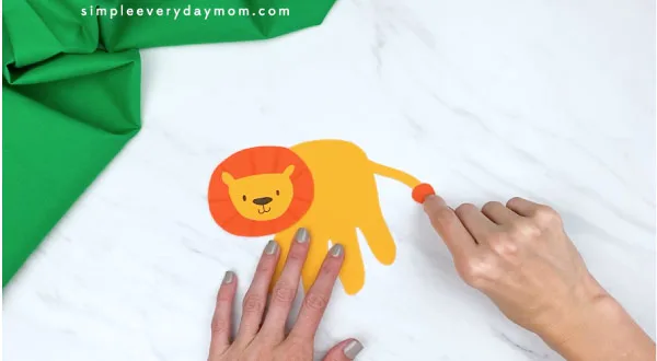 hands gluing on lion tail hair to craft 