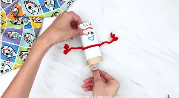 hands gluing on Forky feet to Forky craft 
