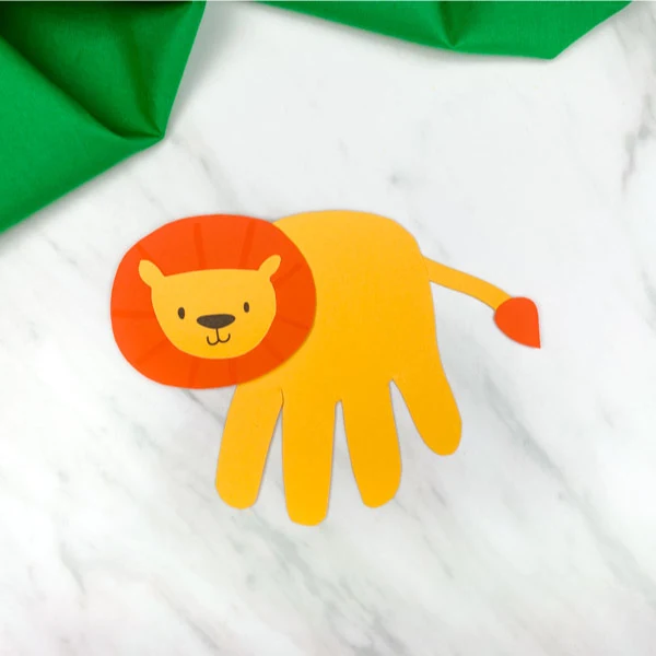 handprint lion craft on marble background with green fabric