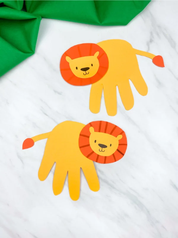 two handprint lions placed vertically with on marble background with green fabric 