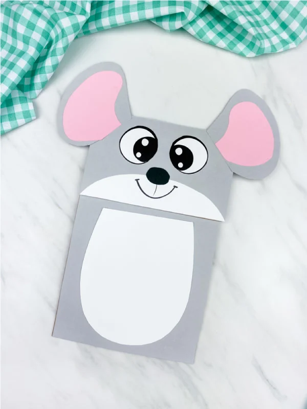 gray paper bag mouse craft on marble background with green checkered fabric