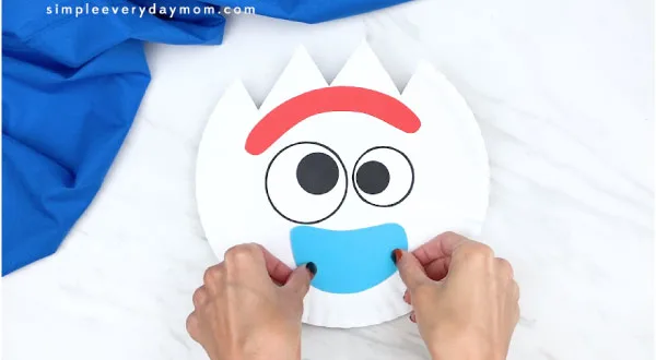 hands gluing on bottom part of Forky's mouth 