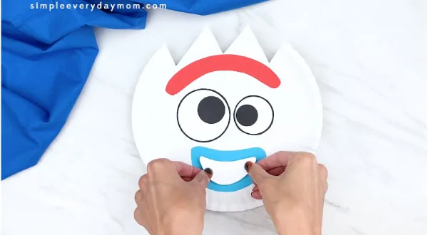 hands gluing on top part of Forky's mouth 