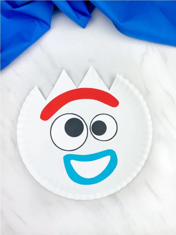 happy paper plate forky craft on marble background with blue fabric 
