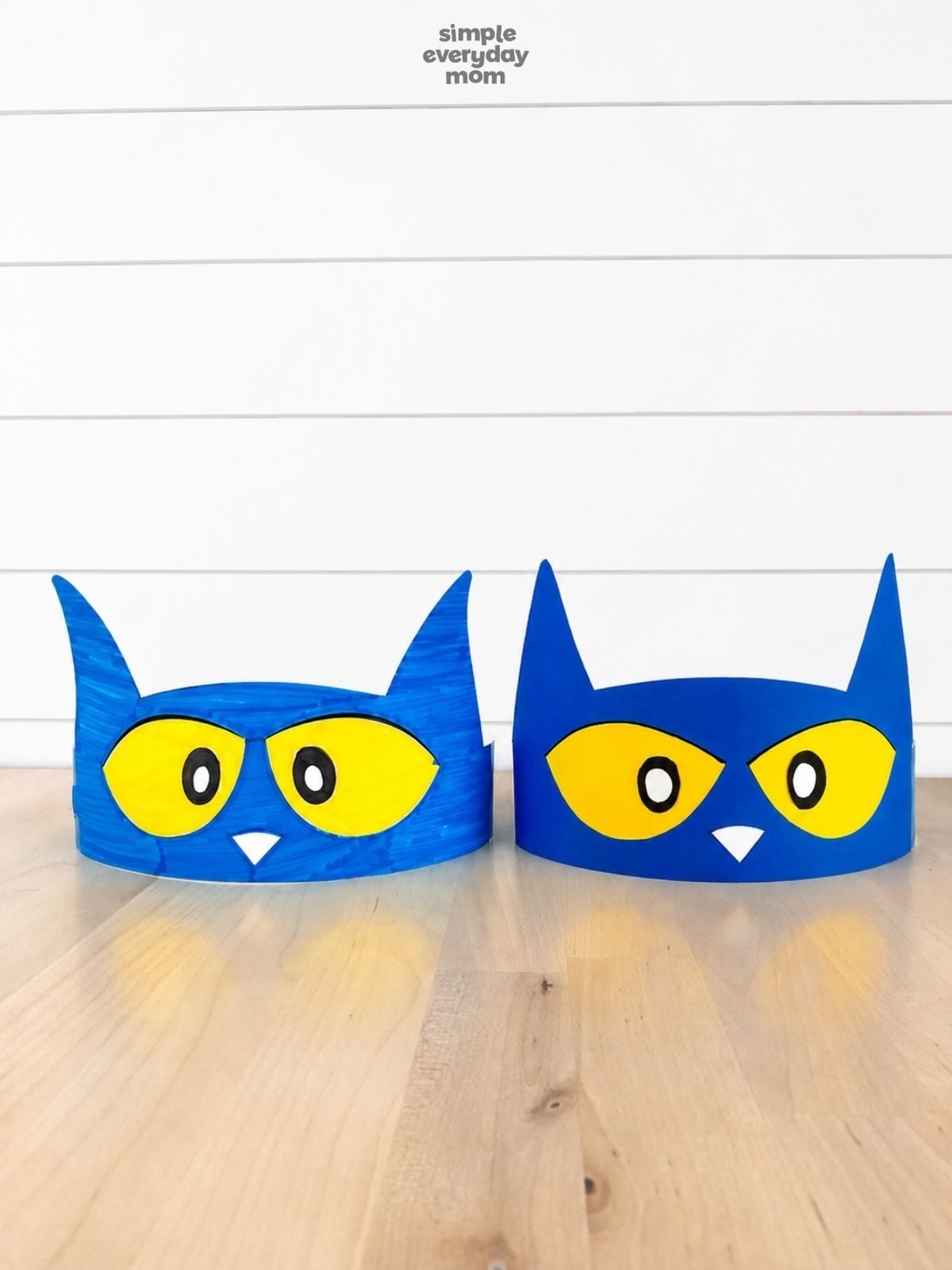 Two finished Pete the Cat headbands, one hand-colored and one made from solid blue paper, displayed side by side.