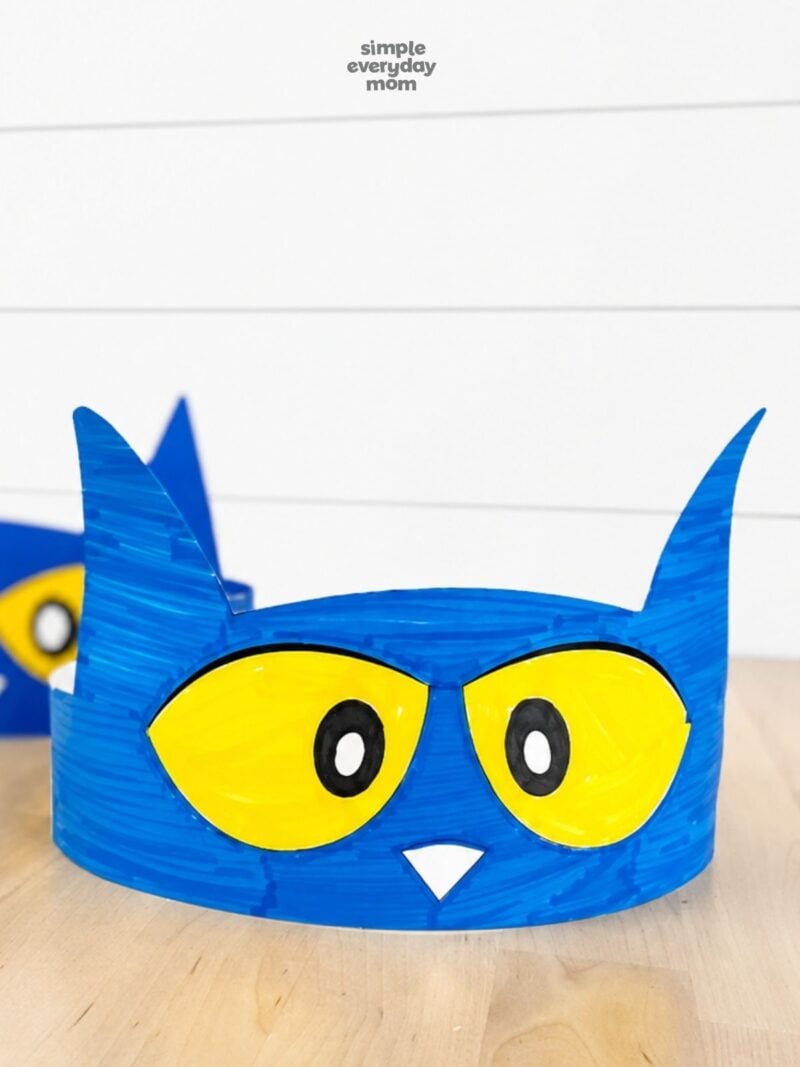Close-up of a hand-colored blue Pete the Cat headband with yellow eyes and a white triangular nose.