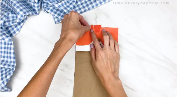 hands gluing on stripes on paper bag cat craft 