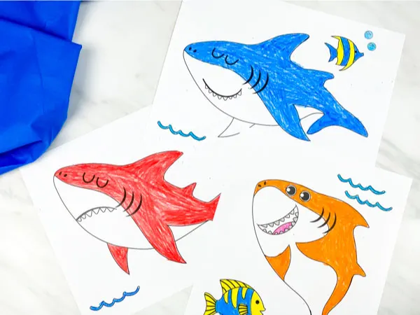 red, blue and orange shark coloring pages on marble background with blue fabric