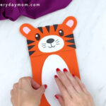 hands gluing stomach to tiger