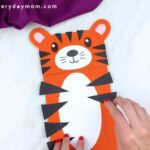 hands gluing stripes onto tiger