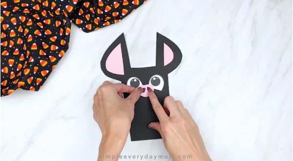 hand gluing nose onto paper bat craft