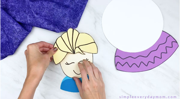 hands gluing paper Elsa hair to head