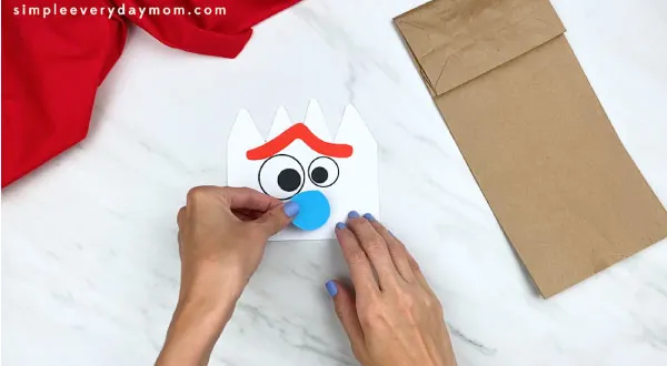 hands gluing mouth onto forky's face