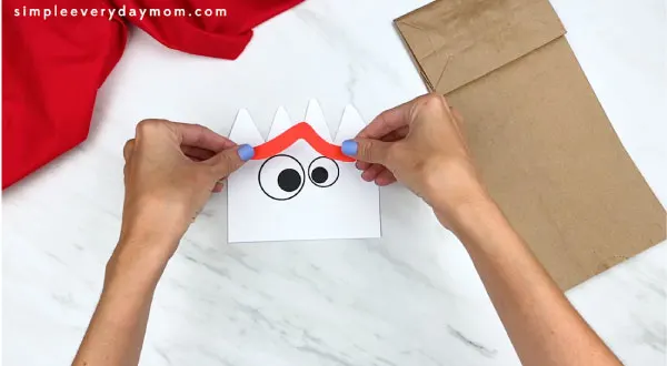 hands gluing forky's eyebrows onto face