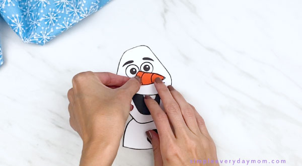hand gluing Olaf nose to face