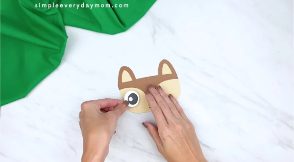 hands gluing eyes to paper squirrel head