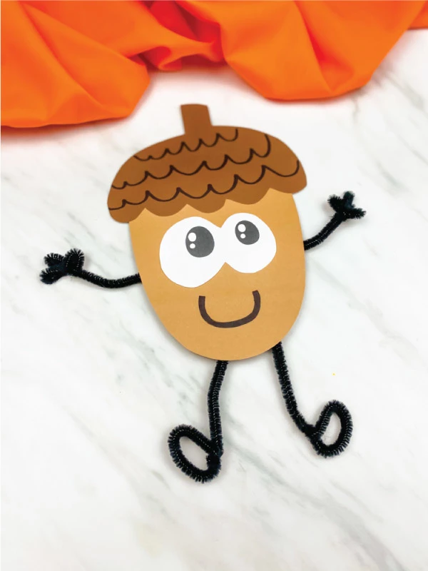paper acorn craft with black pipe cleaner arms and legs