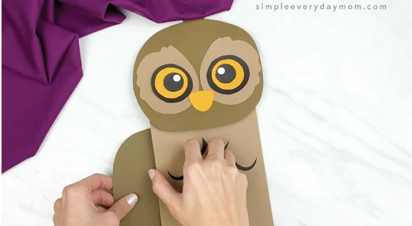 hands gluing wings onto paper bag owl craft