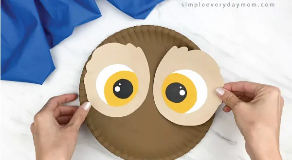 hands gluing eyes to paper plate