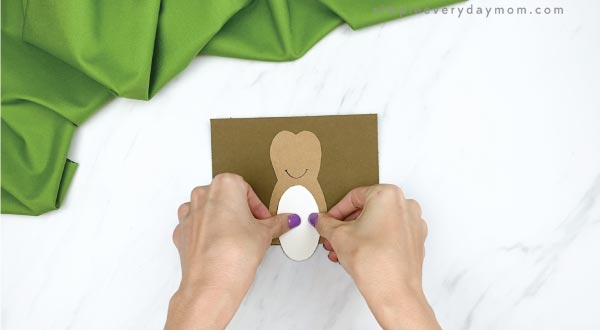 hands gluing belly to toilet paper roll hedgehog craft