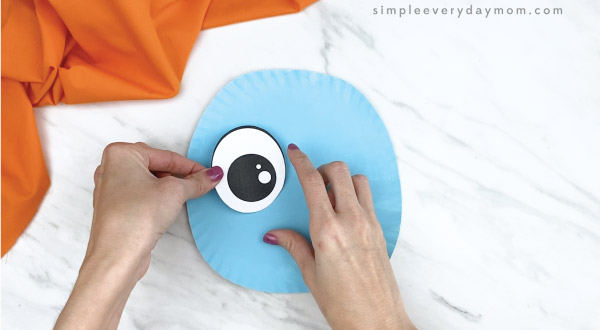 hands gluing eyes onto paper plate elephant craft