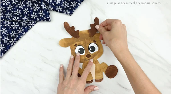 hands gluing antlers to printable reindeer craft
