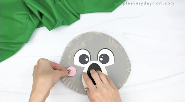 hand gluing cheek to paper plate koala