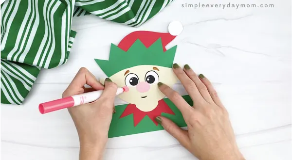 hands drawing cheek onto elf headband craft