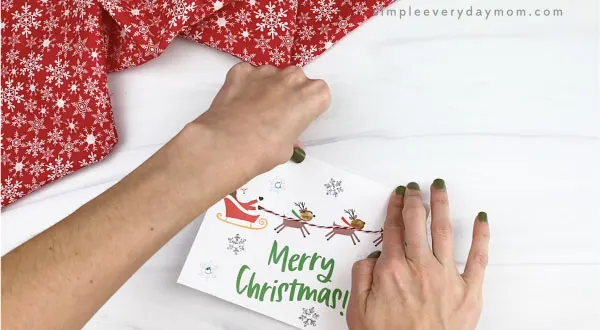 hands folding homemade christmas card in half