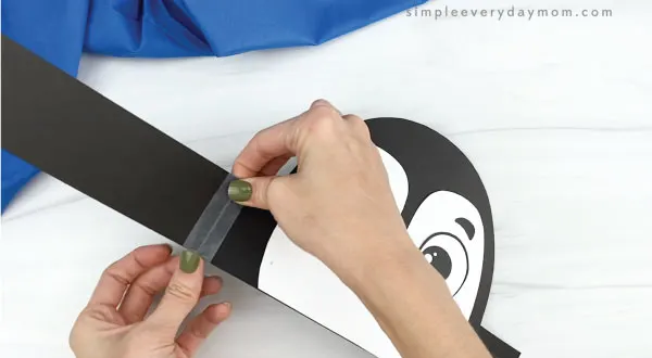 hands taping headband extenders on penguin headband craft