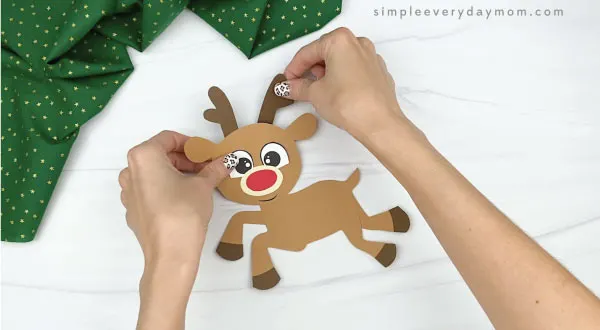 hands gluing antlers to paper rudolph craft