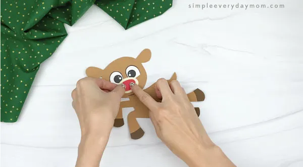 hands gluing nose to paper rudolph craft